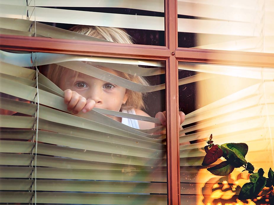 Child Looking Through Blinds.